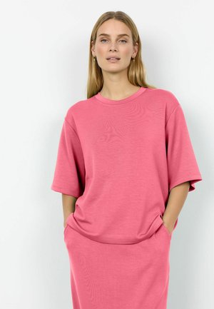 Pink cotton t-shirt dress with short sleeves, round neckline, two side pockets, and a relaxed fit. Smooth texture and simple design.