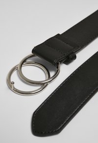 Cintura in pelle nera dal design elegante, con due anelli circolari in metallo argentato come fibbia. Texture liscia e bordi rifiniti.