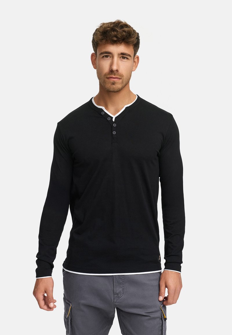 Sort henley-shirt med lange ærmer, hvid kontrastkrave og tre-knaps lukning; blødt stof, tætsiddende design og glat tekstur.