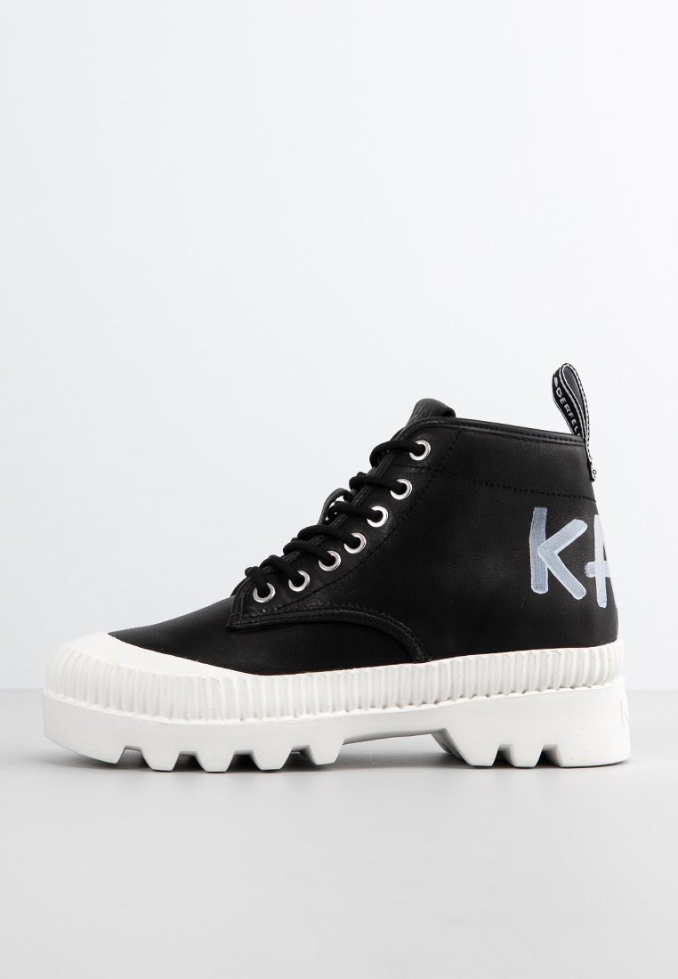 Baskets montantes noires en cuir lisse, avec une semelle épaisse blanche, des lacets ronds et un logo latéral bleu clair.