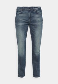 Blå denimjeans med rak passform, blekta detaljer, femfickorsdesign och en klassisk midja. Diskreta stygnaccent är synliga.