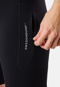 Leggings neri elasticizzati con tasca laterale con zip, caratterizzati da un logo "SWEDEMOUNT" in bianco, texture liscia, design aderente e cuciture piatte.