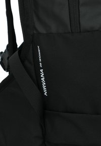 Zaino nero con tessuto texturizzato, dotato di spallacci regolabili. Include lettere bianche: "NIRVANA 28 DONNE." Comparto principale con zip visibile.