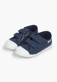 Tumes laevavärvi riidest kingad kahe reguleeritava Velcro rihmaga, valged kummist varbakatted ja tallad, tekstureeritud ülemine osa ja külgpaneeli aktsendid.