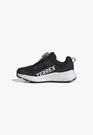 Black athletic shoe with mesh upper, textured accents, a white midsole, and "TERREX" logo. Features a knob for quick adjustment.