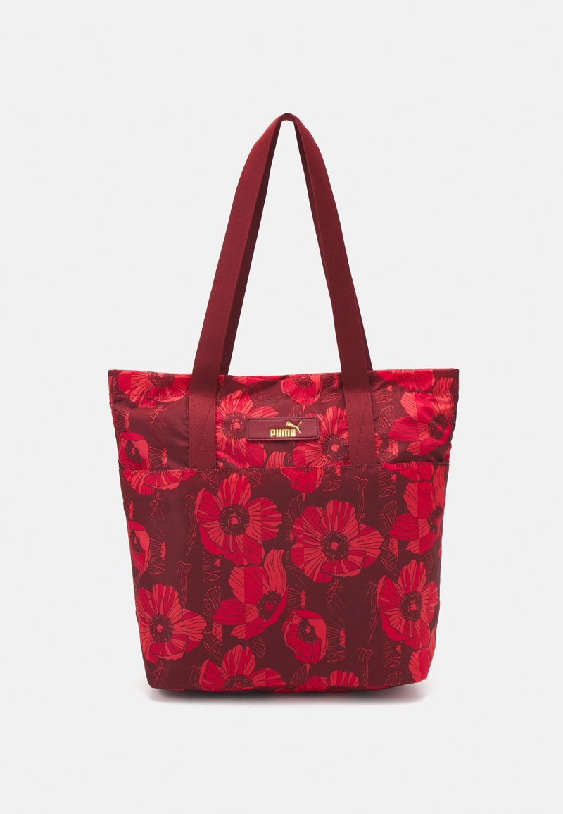Sac fourre-tout rouge avec un grand motif floral rouge, longues anses et un petit logo Puma à l'avant.