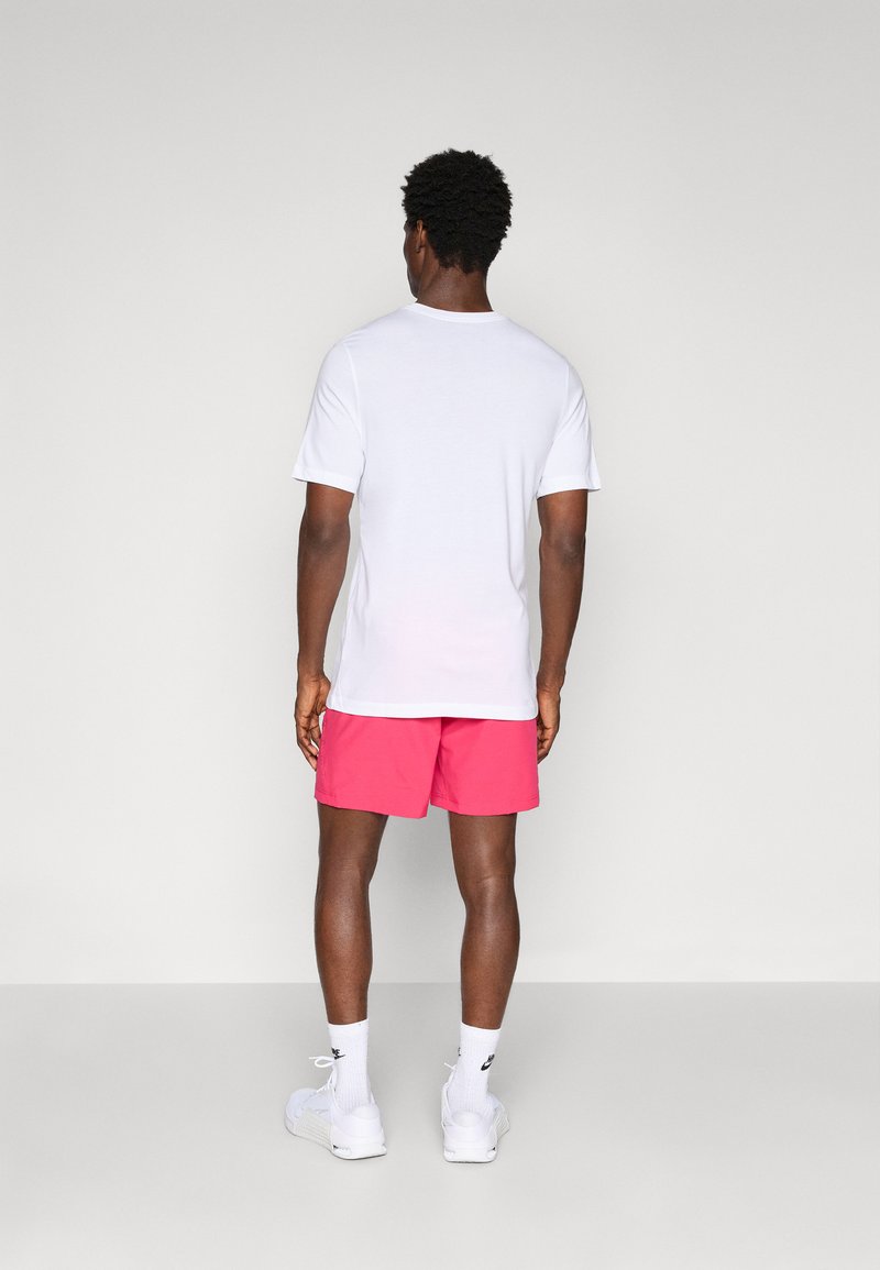 Hvid t-shirt, korte ærmer; lys pink shorts; hvide sneakers; tekstureret stof; ensartet design; set fra ryggen.