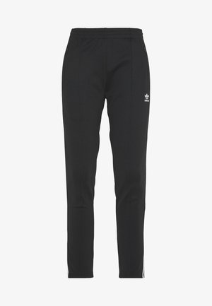 Pantalones deportivos negros con un corte ajustado, hechos de una tela suave, con rayas laterales, bolsillos con cremallera y un logo blanco cerca de la cintura.