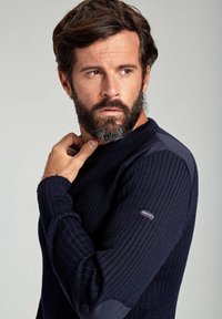 Maglione a coste blu navy con maniche lunghe, dotato di pannelli a contrasto sulle spalle e un piccolo logo del marchio sulla manica sinistra.