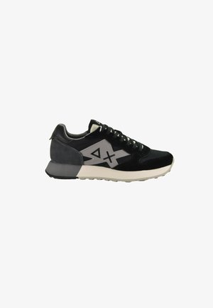 Schwarzer und grauer Sneaker mit einem Obermaterial aus Wildleder und Mesh, ausgestattet mit einer weißen Zwischensohle, strukturiertem Gummisohle und geometrischen Akzenten an den Seiten.