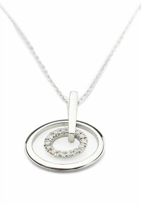 Sudraba kulons kaklarotā ar diviem koncentriskiem riņķiem. Iekšējais gredzens rotāts ar nelielām caurspīdīgām pērlītēm, piekārts pie gludas ķēdītes cilpas.