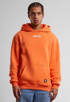 Orange hoodie made of soft fabric, featuring a front pocket, drawstring hood, and white "STARTER" logo on the chest.
