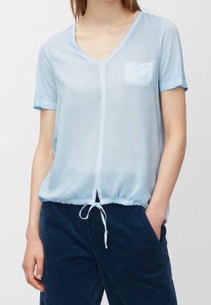 Top azzurro chiaro a maniche corte con scollo a V, orlo con cordino e una piccola tasca sul petto. Tessuto liscio e leggero con una vestibilità rilassata.
