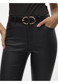 Pantalon en similicuir noir à finition élégante, avec une ceinture noire dotée d'une boucle ovale dorée, coupe slim et poches latérales.