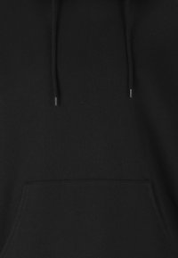 Svart huvtröja i mjukt material, med en framficka och dragband med silverfärgad spets. Enkel design utan synliga mönster.