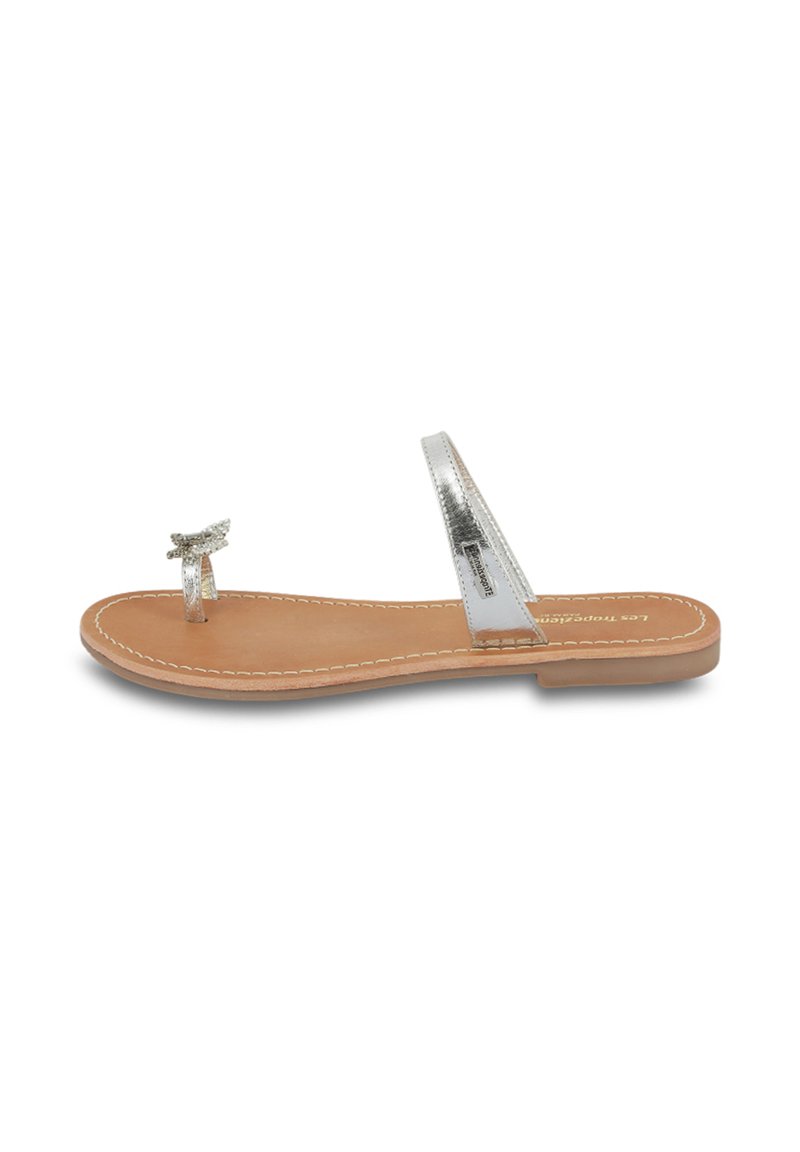 Silver flat sandals with a translucent strap and a small bow accent; features a flat, tan insole with white stitching along the edges.