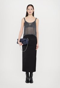 Metāliski pelēks adīts cropped tops, melna garā svārki, melni potītes zābaki un zils somiņš ar ķēdes siksniņu. Vienkāršs un mūsdienīgs dizains.