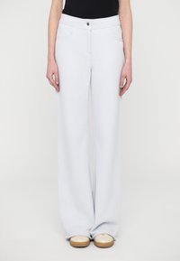 Light blue wide-leg pants made of soft fabric, featuring a front button closure, two side pockets, and a relaxed fit.