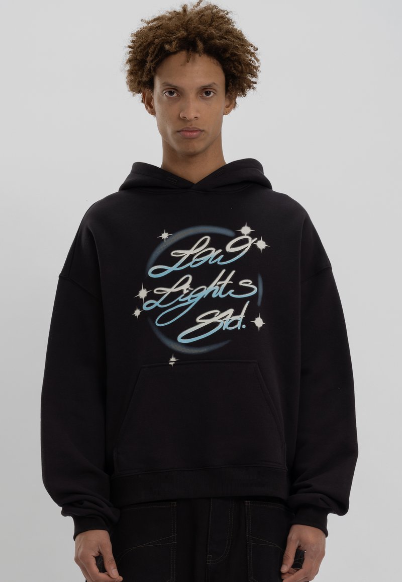 Zwarte hoodie gemaakt van zacht materiaal, met een grafische print met blauwe en witte tekst en steraccenten aan de voorkant.
