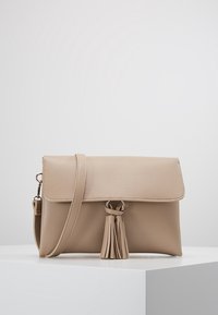 Borsa a tracolla in pelle beige con finitura testurizzata, chiusura a patta, dettaglio con frange sul davanti e tracolla removibile.