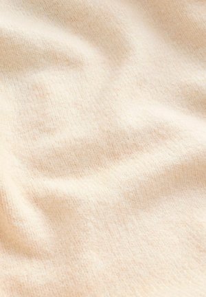 Cremefarbener, strukturierter Stoff mit einer weichen, flauschigen Oberfläche und subtilen Rippungen, die sanfte Falten und Wellen zeigen.