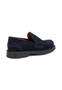 Zapatos de ante azul marino tipo mocasín con punta redonda, costuras decorativas y suela de goma negra. Cuentan con un cuello acolchado para mayor comodidad.