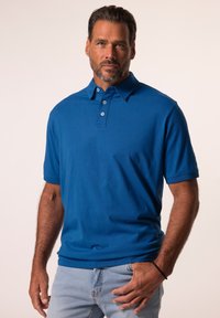 Polotröja i enfärgad blå tyg, med knappslå, korta ärmar och avslappnad passform. Slät textur utan mönster.