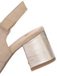Beige suede sandal with adjustable strap and metallic block heel, featuring cushioned insole and rounded edges.