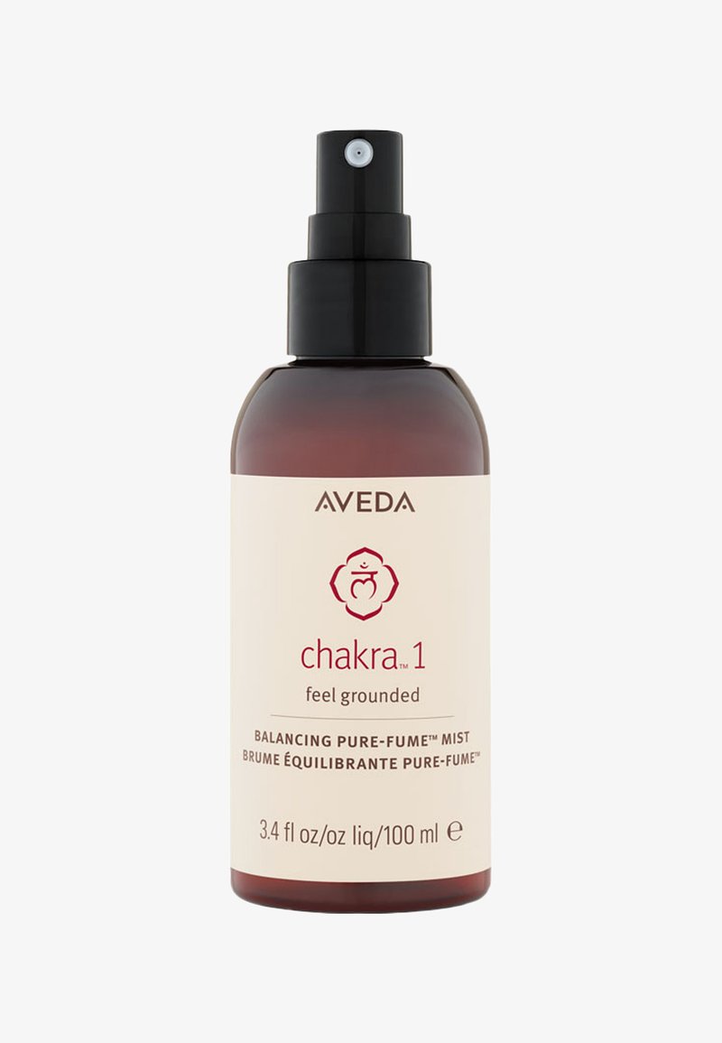 Aveda Chakra 1 Spray in einer braun getönten Glasflasche mit einer schwarzen Sprühdüse; die cremefarbene Etikette zeigt roten Text und ein Symbol.
