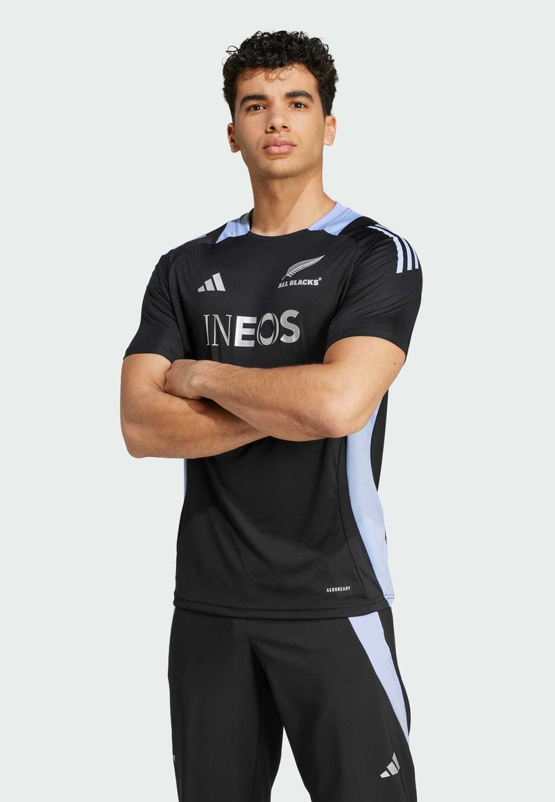 Černý atletický dres se světle modrými akcenty, s nápisem "INEOS" v stříbrné a logem "ALL BLACKS". Vyrobeno z prodyšného materiálu.