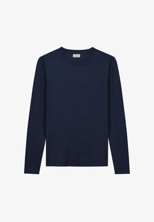 T-shirt à manches longues bleu marine en coton doux, avec un col rond et un logo minimaliste sur la poitrine. Texture lisse, sans motifs.