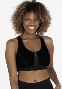 Black sports bra with a front zipper, contrasting seams, and a fitted design. Made from textured fabric, featuring a scoop neckline and wide straps.