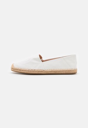 Hvid slip-on espadrille-sko med flettet jutesål og glat overdel, vist fra siden på en ensfarvet lys baggrund.