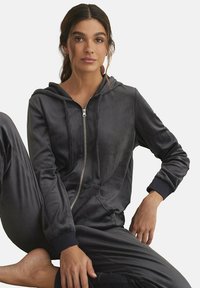 Donkergrijze hoodie jasje met rits gemaakt van zachte stof, met ribgebreide manchetten en bijpassende joggingbroek. Gladde textuur met een relaxte pasvorm.