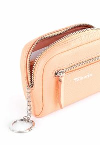 Peach-colored leather wallet with a textured finish, featuring dual zippers and a chain keyring. Brand logo visible on the side.
