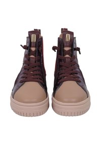 Baskets montantes en cuir bordeaux et beige, avec des lacets marron, des accents texturés et une semelle en caoutchouc avec un motif de crampon bien marqué.