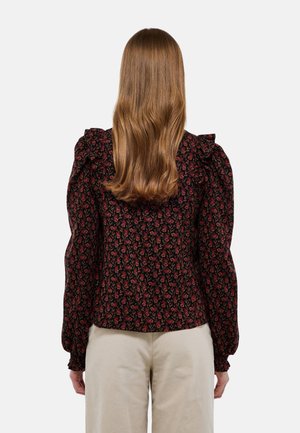 Blouse noire à motifs floraux avec des manches bouffantes, motif de roses rouges, et poignets élastiques. Tissu léger avec une coupe ajustée et un col volanté.