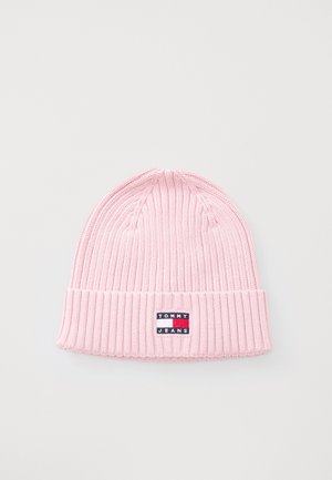 Roza pletiva kapa s rebrastim uzorkom i preklopom, s pravokutnom oznakom koja glasi "TOMMY JEANS" u kontrastnim bojama.