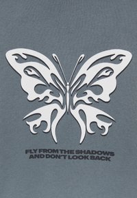 Graphique blanche stylisée de papillon sur fond gris avec le texte « Vole depuis l'ombre et ne regarde pas en arrière » en dessous.
