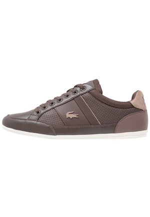 Brown low-top sneaker with perforated sides, lace-up closure, beige logo, and white sole, displayed in profile on a white background.