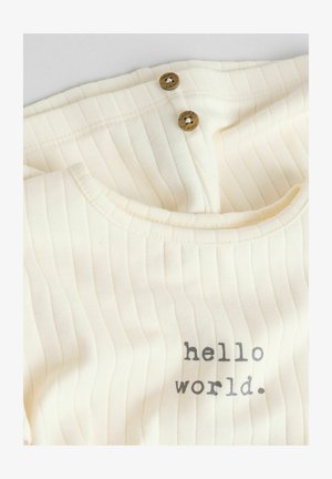 Béžovo-ribana otroška bodi ima okrogel izrez, dva lesena gumba in natisnjen napis "hello world."