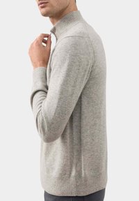 Lichtgrijze wolmix trui met een hoge ribbelkraag en lange mouwen, met een zachte textuur en een slim fit ontwerp.