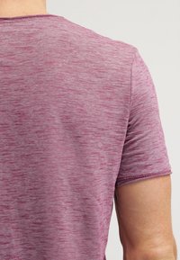 T-paita lyhyillä hihoilla, pyöreällä kaula-aukolla harmahtavassa vaaleanpunaisessa, jossa on pehmeä rakenne, hienovaraisia värivaihteluita ja siistit saumat.