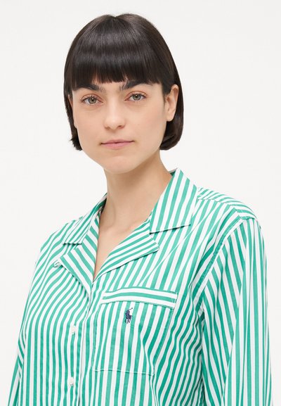 Zelena in bela črtasta pižama srajca z žepom in ovratnikom v obliki notcha. Narejena je iz gladkega blaga z navpičnimi črtami in majhnim logotipom.