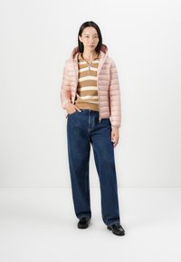 Rosa dunjakke med hette, krem- og brune stripete strikkegenser, mørkeblå vide jeans, svarte sko. Glatt tekstur og quiltet design.