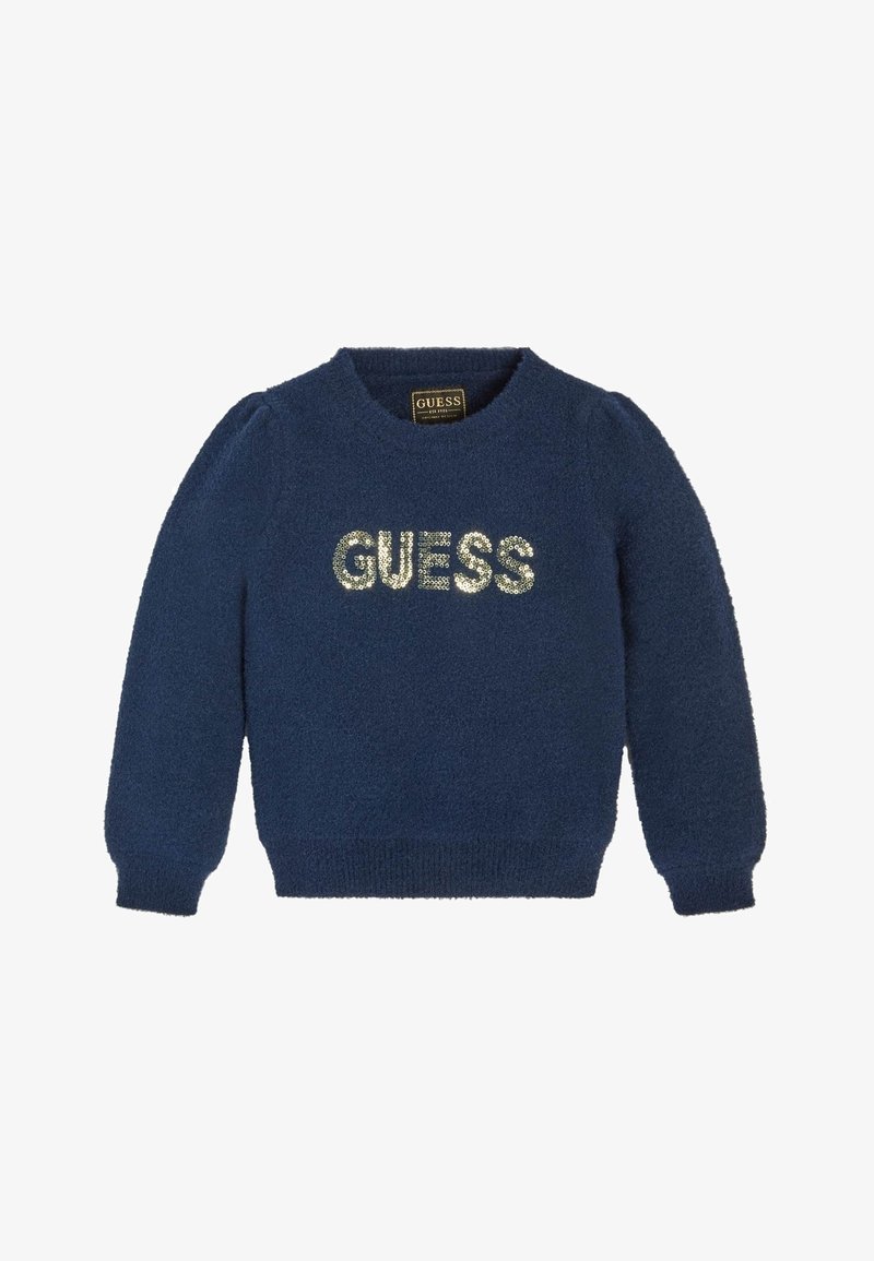 Pull bleu marine duveteux à manches longues avec le mot « GUESS » en sequins argentés sur la poitrine.