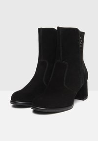 Černé semišové kotníkové boty s kulatou špičkou, zipem, masivním podpatkem a kontrastním prošíváním. Hladký povrch a minimalistický design.