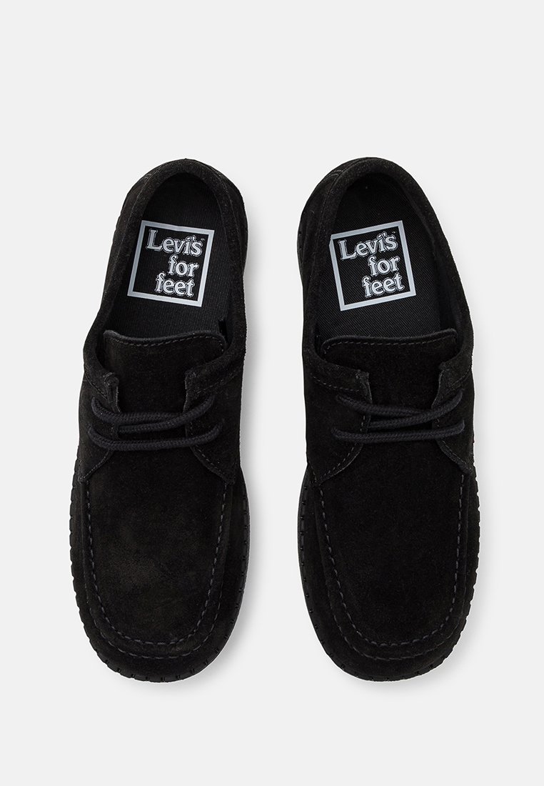 Chaussures décontractées en daim noir avec un bout rond, dotées d'un système de laçage et d'une couture complexe le long de la semelle. Logo sur la semelle intérieure.