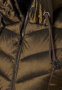 Kurtka puchowa w oliwkowej zieleni, z zamkiem błyskawicznym, regulowanymi sznureczkami i pikowaną teksturą z ukośnym przeszyciem.