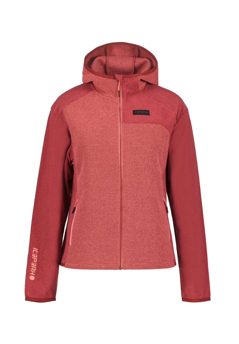 Veste à capuche rouge en tissu texturé, avec fermeture éclair à l'avant et deux poches latérales zippées. Logo affiché sur la poitrine et la manche.